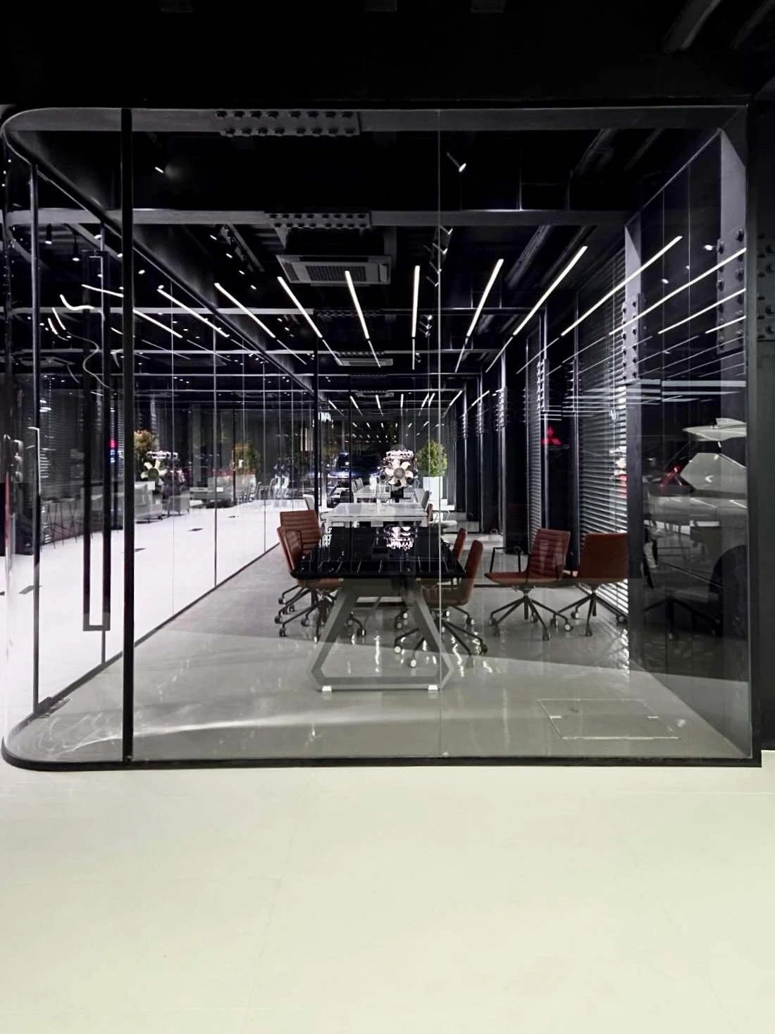 Photograph of the rounded glass meeting room inside the completed showroom.