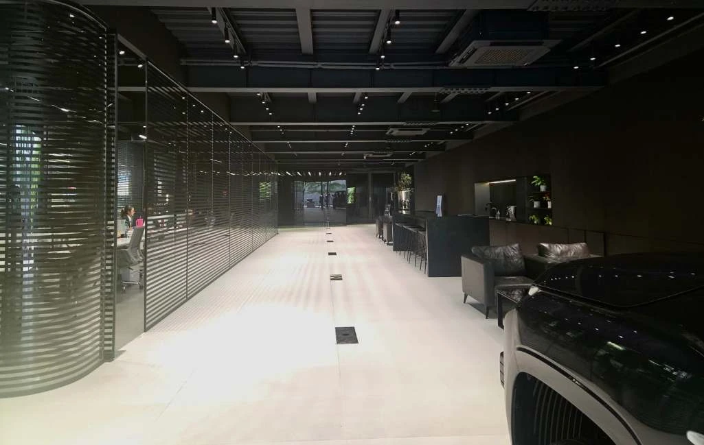 Photograph looking along the showroom walkway beside the glazed office and black reception counter.