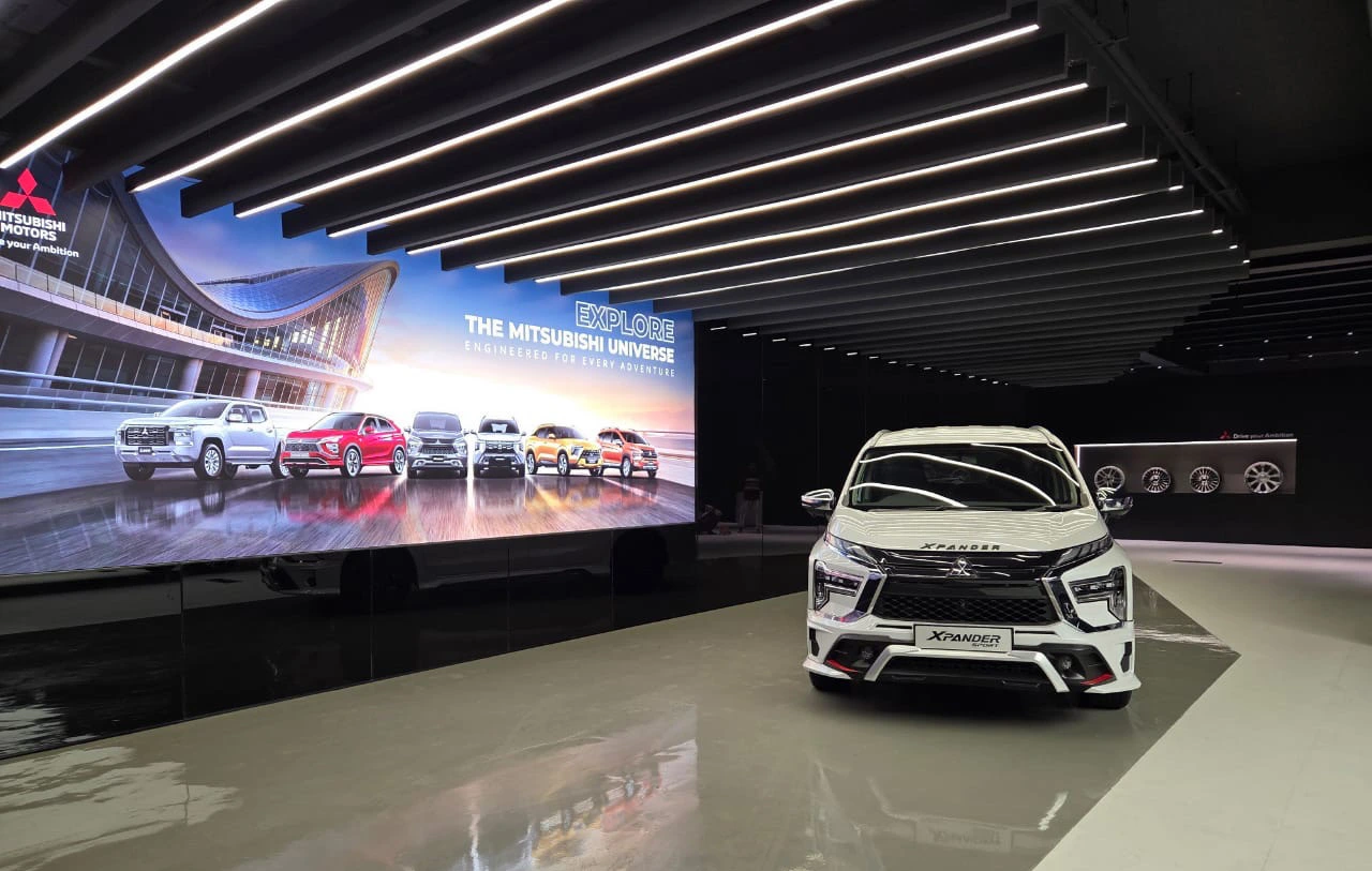 Photograph of the showroom feature screen, linear lights and a white Mitsubishi vehicle.